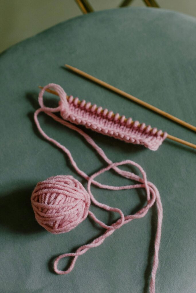 knitting needles with pink yarn 